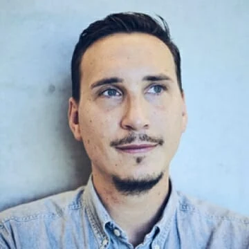 A man in denim looks upward, standing under cannabis LED grow lights display.