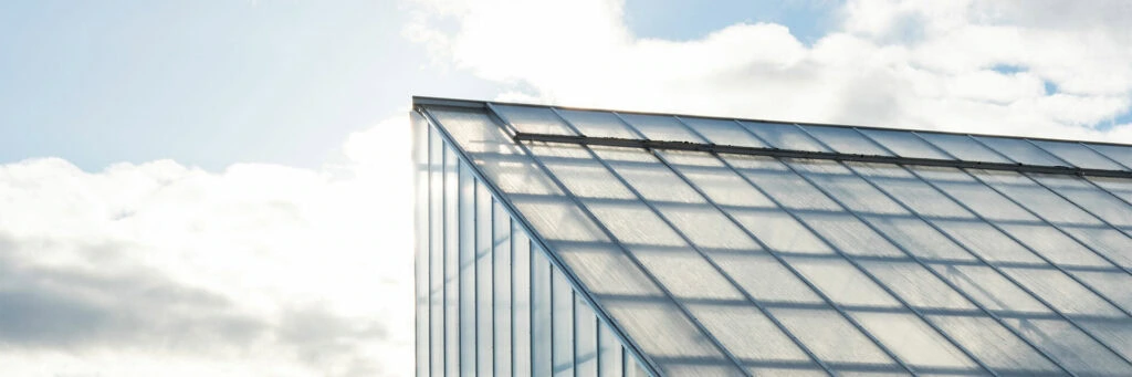 Glass greenhouse roof with sunlight, illustrating cannabis lighting technology.