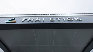 Eine Markise an einem Gebäude mit der Aufschrift „THAI STICK“, die für LED-Zuchtleuchten für den Cannabisanbau wirbt.