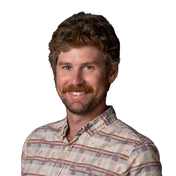 Smiling man with curly brown hair, showcasing cannabis lighting technology.
